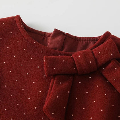 Close-up of the bow on a red dotted girls pinafore dress