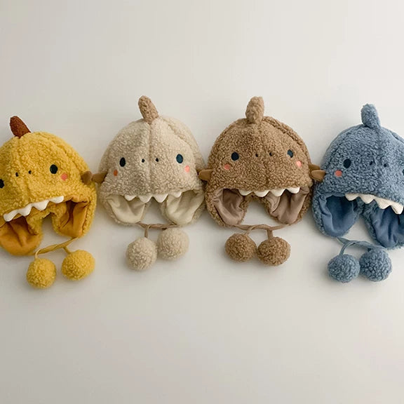Dinosaur earflap hats in mustard, oat, caramel and denim blue