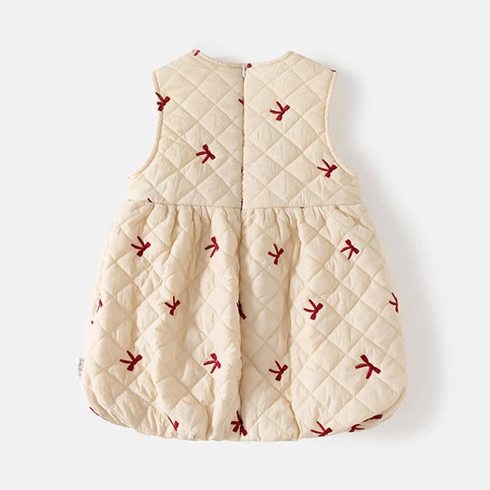 Back of the cream quilted pinafore dress showing the hidden back zip and bubble hem