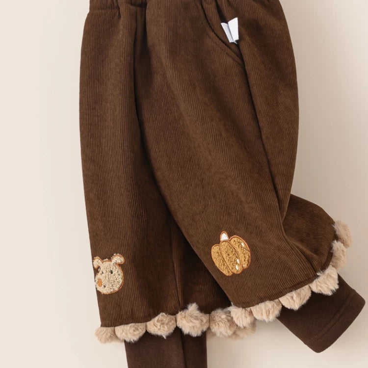 Close-up of embroidered pumpkin and bear on cocoa corduroy pants