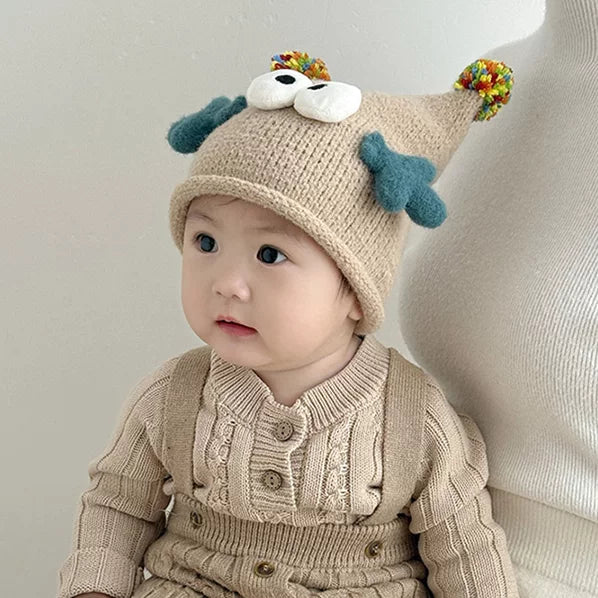 Toddler in an oatmeal monster beanie looking to the side