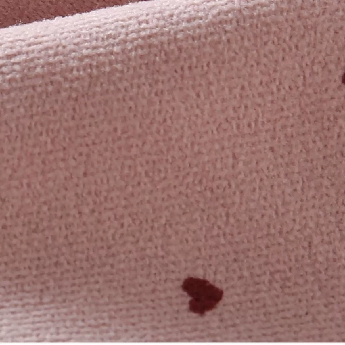 Close-up of the soft brushed pink fabric with tiny red hearts