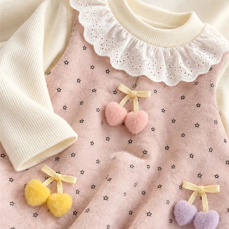 Close-up of the fluffy pink, yellow and lilac heart charms on the pinafore