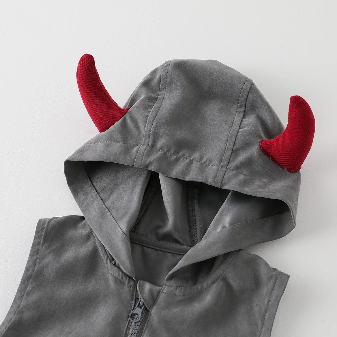 Close-up of the hood with soft red devil horns and front zip