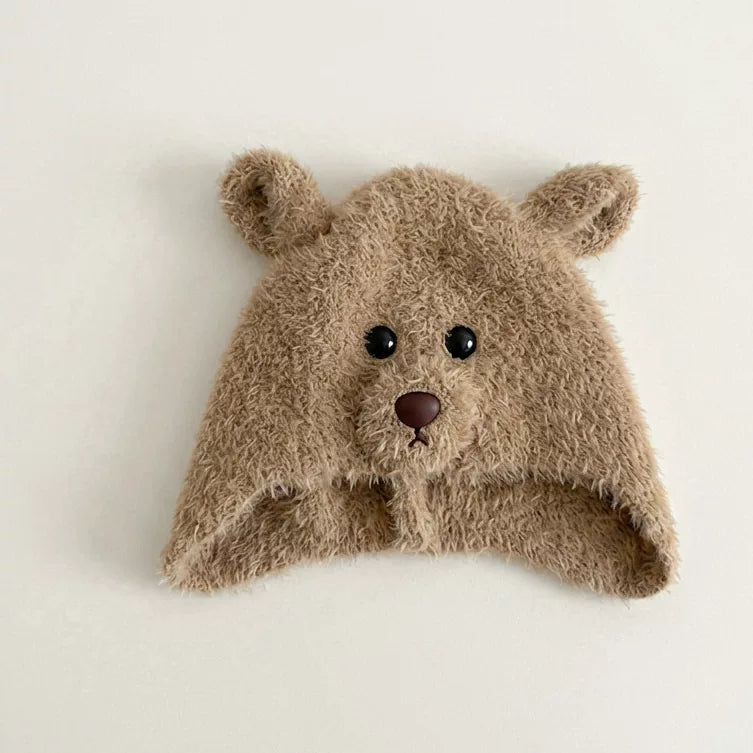 Latte brown plush bear hat with ears and ear flaps, flat lay