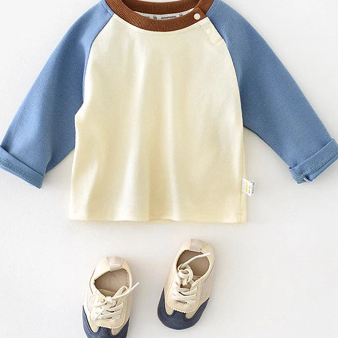 Cream baby tee with blue raglan sleeves and a brown ribbed neckline