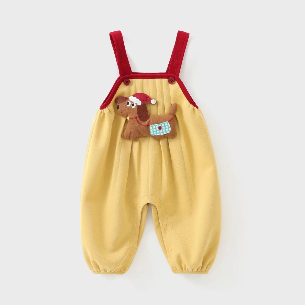 Mustard baby overall romper with red straps and plush puppy appliqué, flat lay