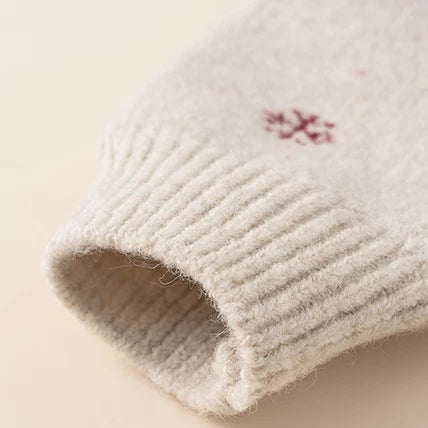 Ribbed sweater cuff with red snowflake knit detail