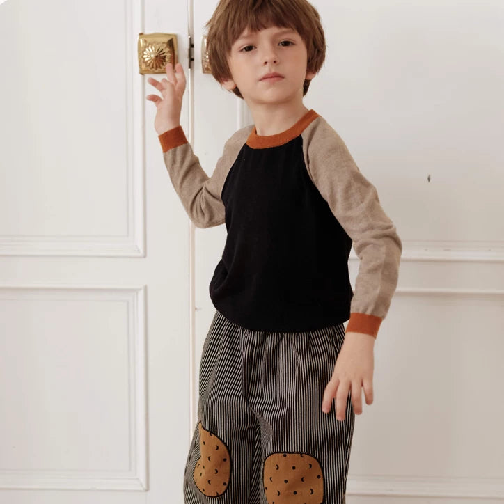 Boy wearing charcoal striped fleece-lined pants with cookie knee patches