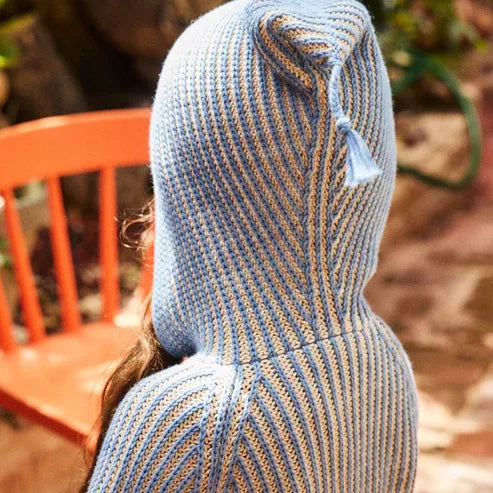 Back view of the pointed pixie hood with tassel on a blue knit cardigan