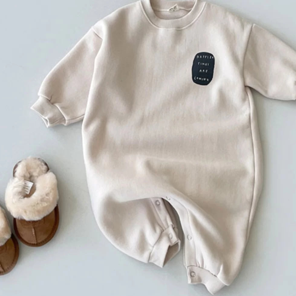 Oat beige fleece-lined baby onesie with ribbed cuffs and snap legs