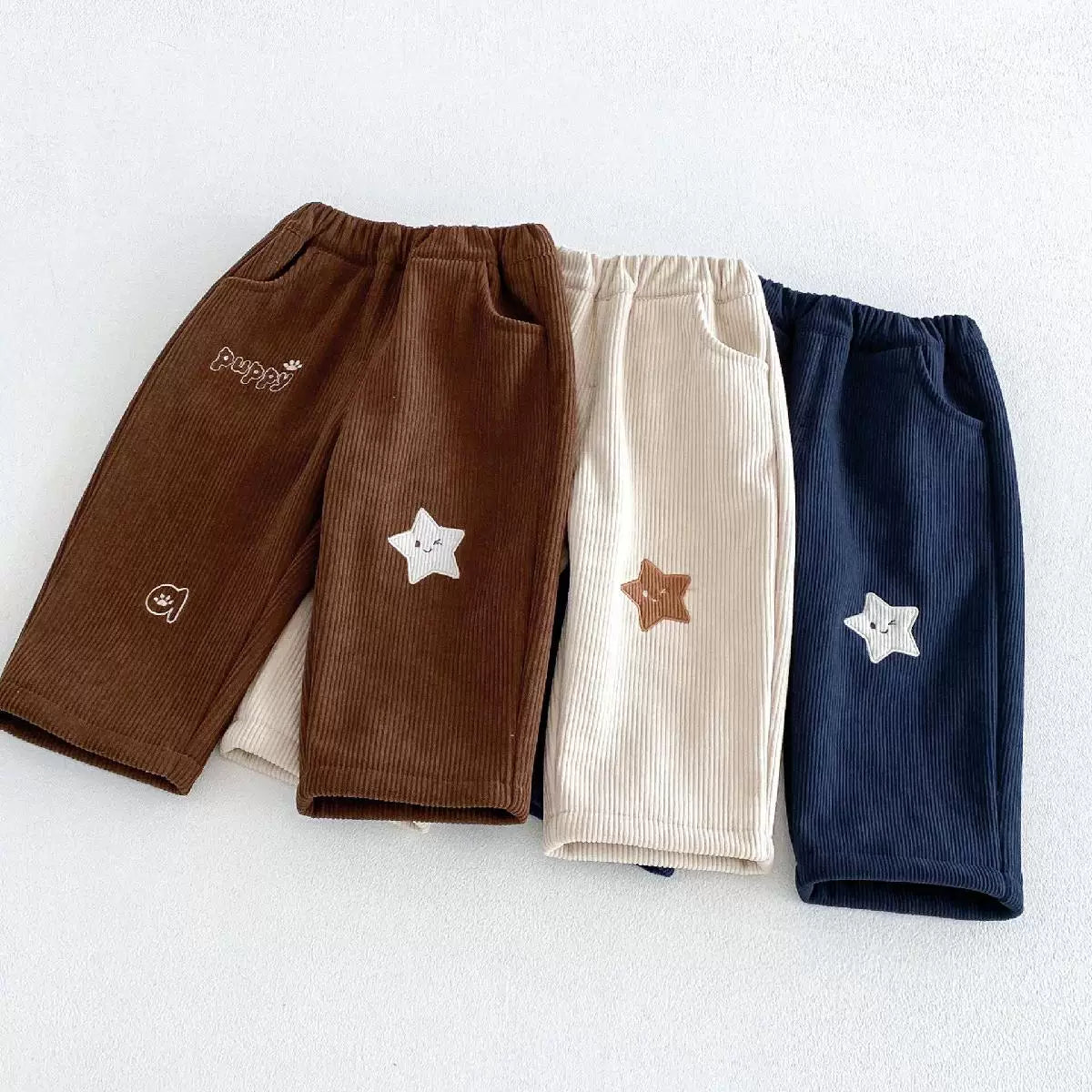 Three pairs of kids corduroy straight-leg pants in brown, cream and sapphire