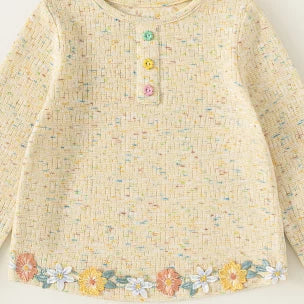 Front of the girls tee with three flower-shaped buttons