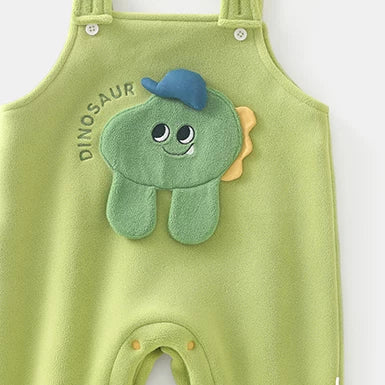 Close-up of green fleece baby overalls with dinosaur appliqué and snap legs