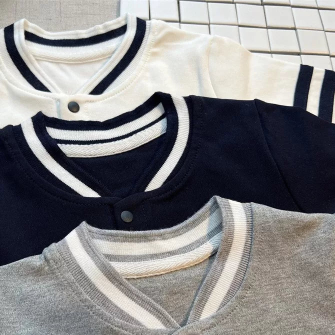 Close-up of the striped rib collars on the white, navy and grey rompers