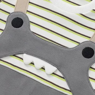 Close-up of the appliqué dino face with soft 3D teeth and snap shoulder strap
