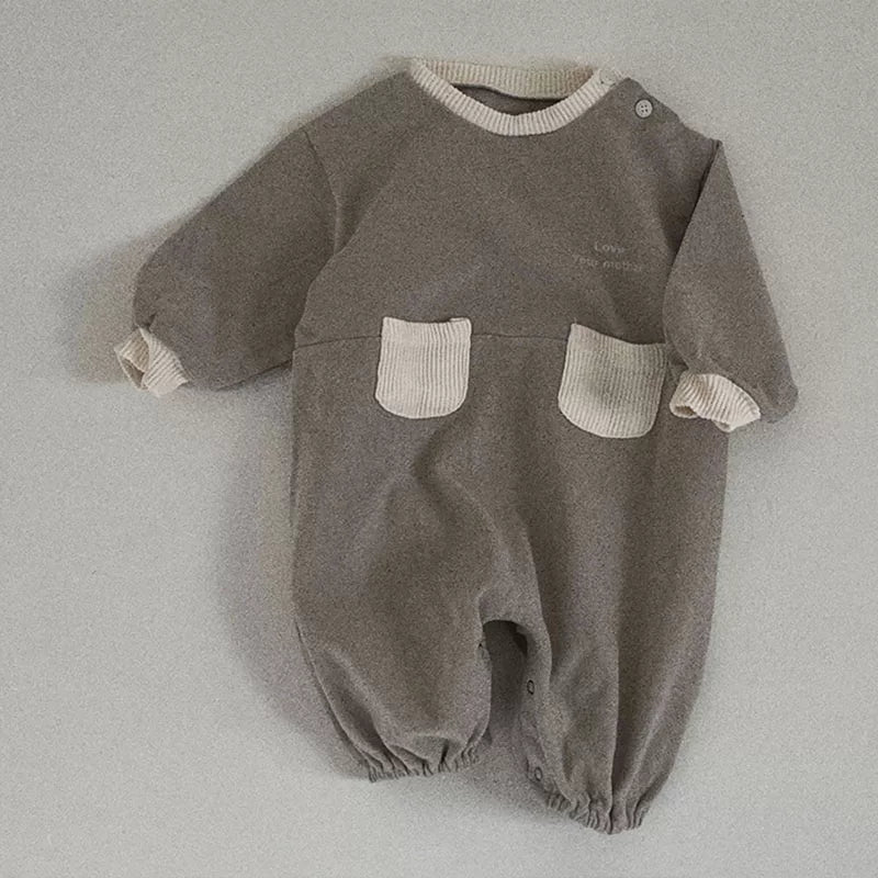 Stone grey long-sleeve baby romper with cream knit pockets, flat lay