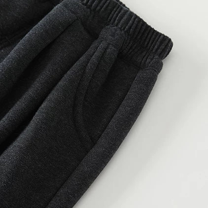 Close-up of soft elastic waistband and side pocket on charcoal baby pants