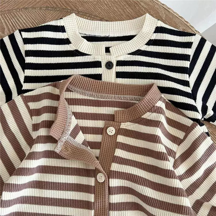 Close-up of the round neckline and button placket on the striped romper