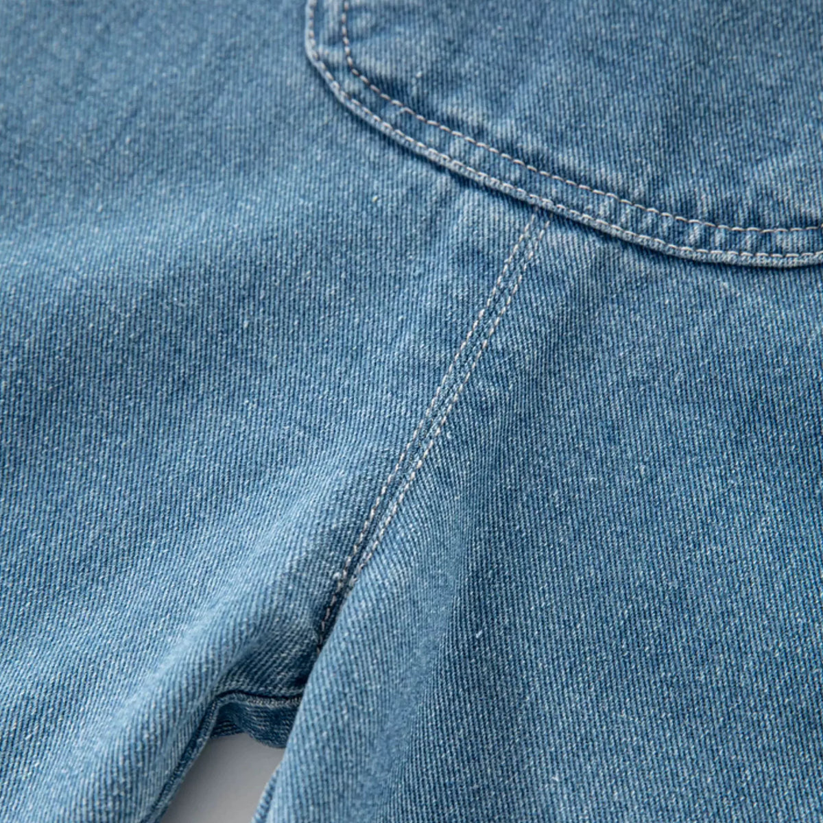 Denim texture and contrast stitching on toddler overalls