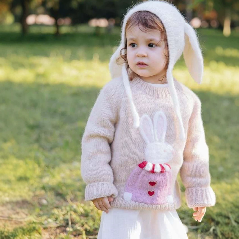 Toddler girl in a vintage-style bunny knit sweater outdoors