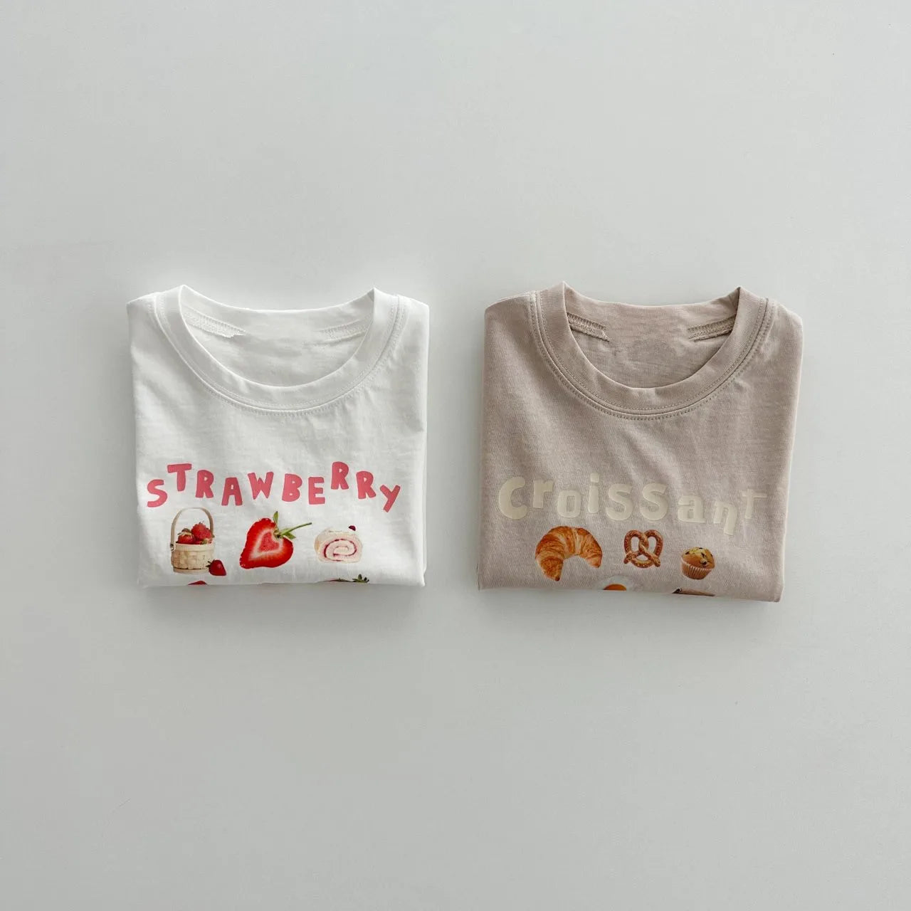Strawberry and croissant print baby toddler t-shirts folded, white and beige