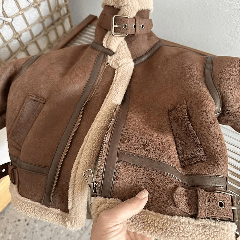 Close-up of sherpa collar and buckle strap on aviator jacket
