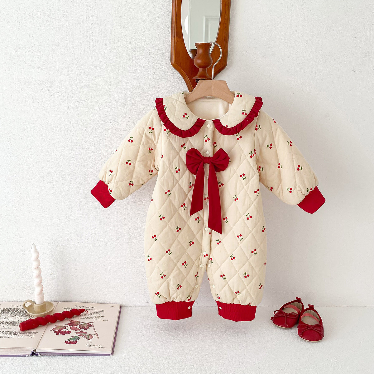 Baby girl cherry quilted winter jumpsuit with red bow, hanging