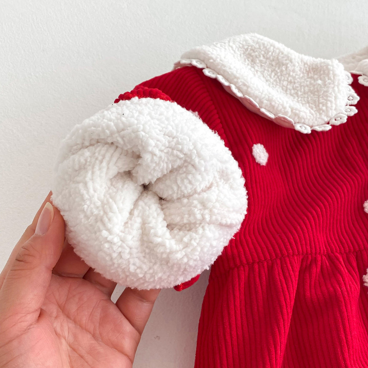 Sherpa-lined sleeve of red polka dot jumpsuit