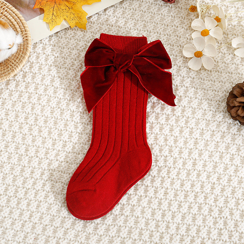 Red ribbed knee-high baby socks with velvet bow