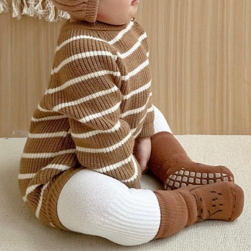 Baby sitting in brown striped knit romper