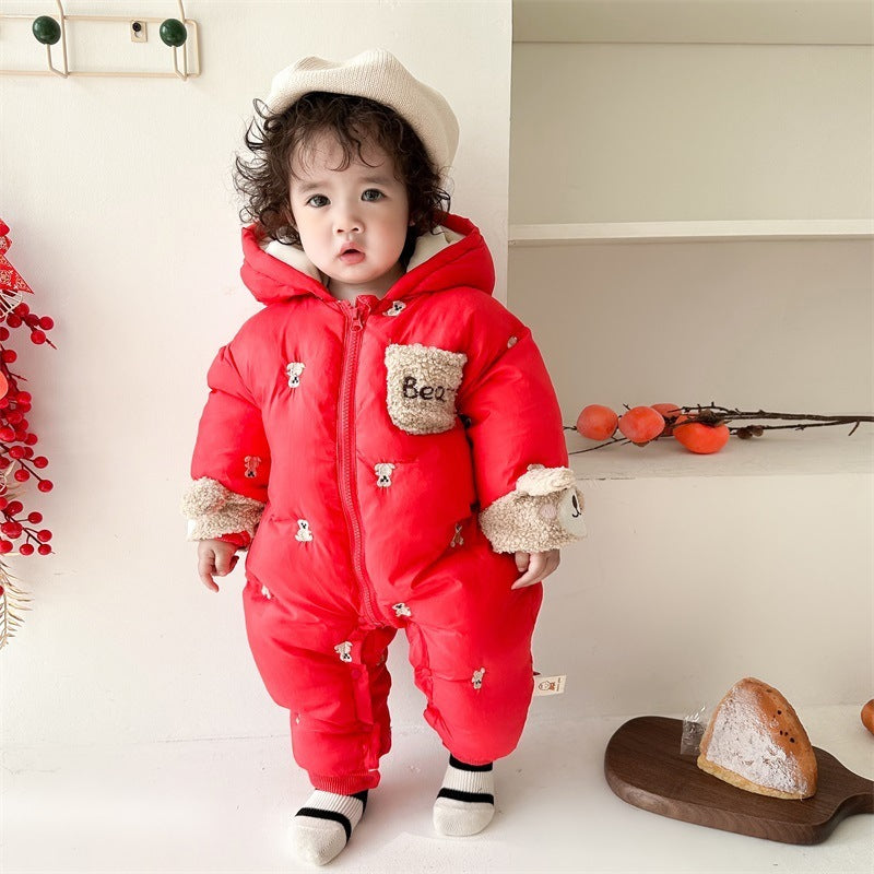 Baby standing in red bear ears snowsuit