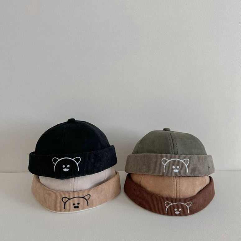 Four bear embroidered corduroy baby hats side by side