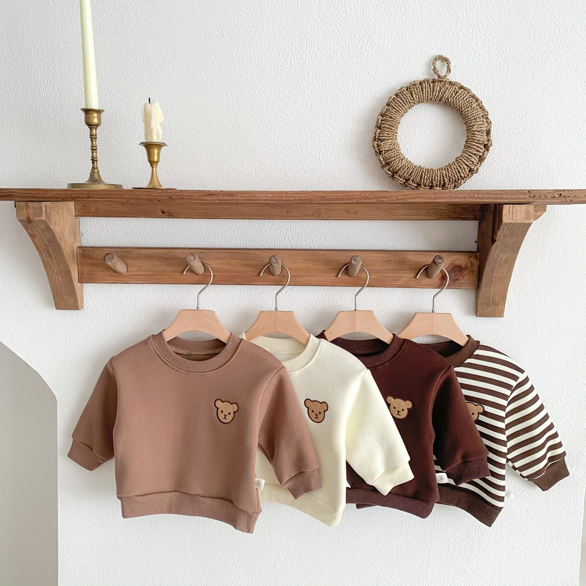 Bear patch sweatshirts in several colours on a peg rail