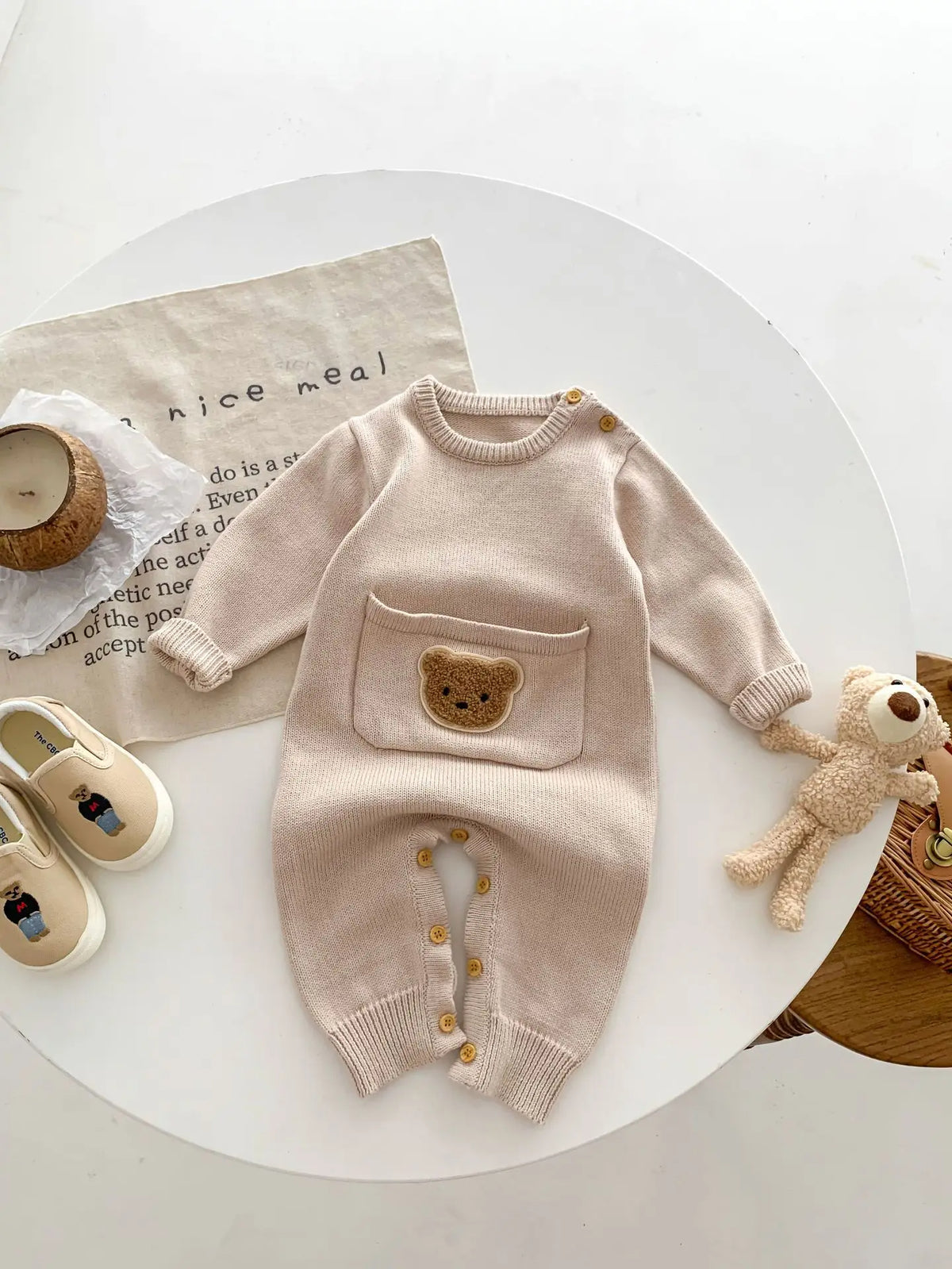 Oatmeal knit baby romper with bear pocket laid flat