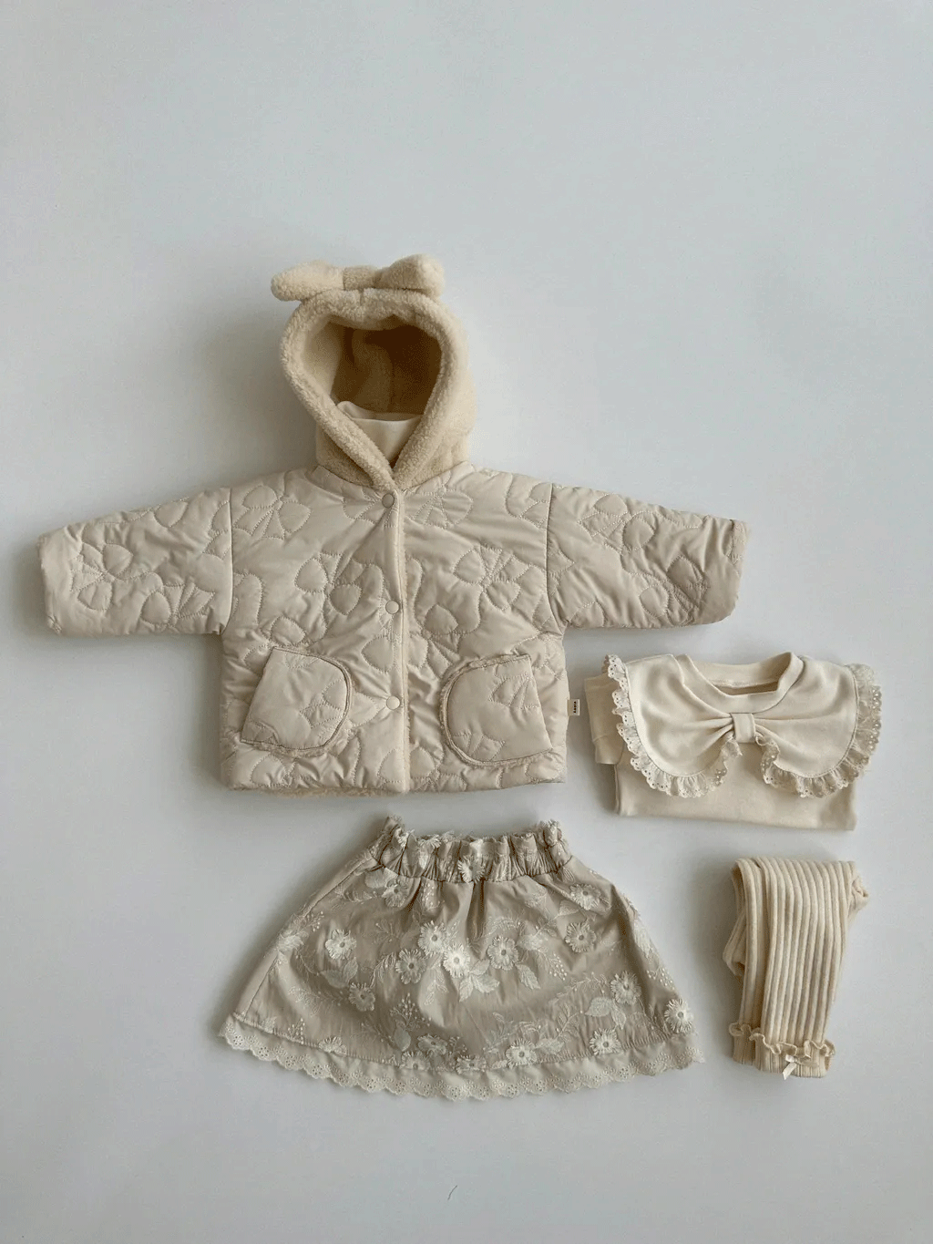 Beige bow hood jacket styled with skirt and accessories