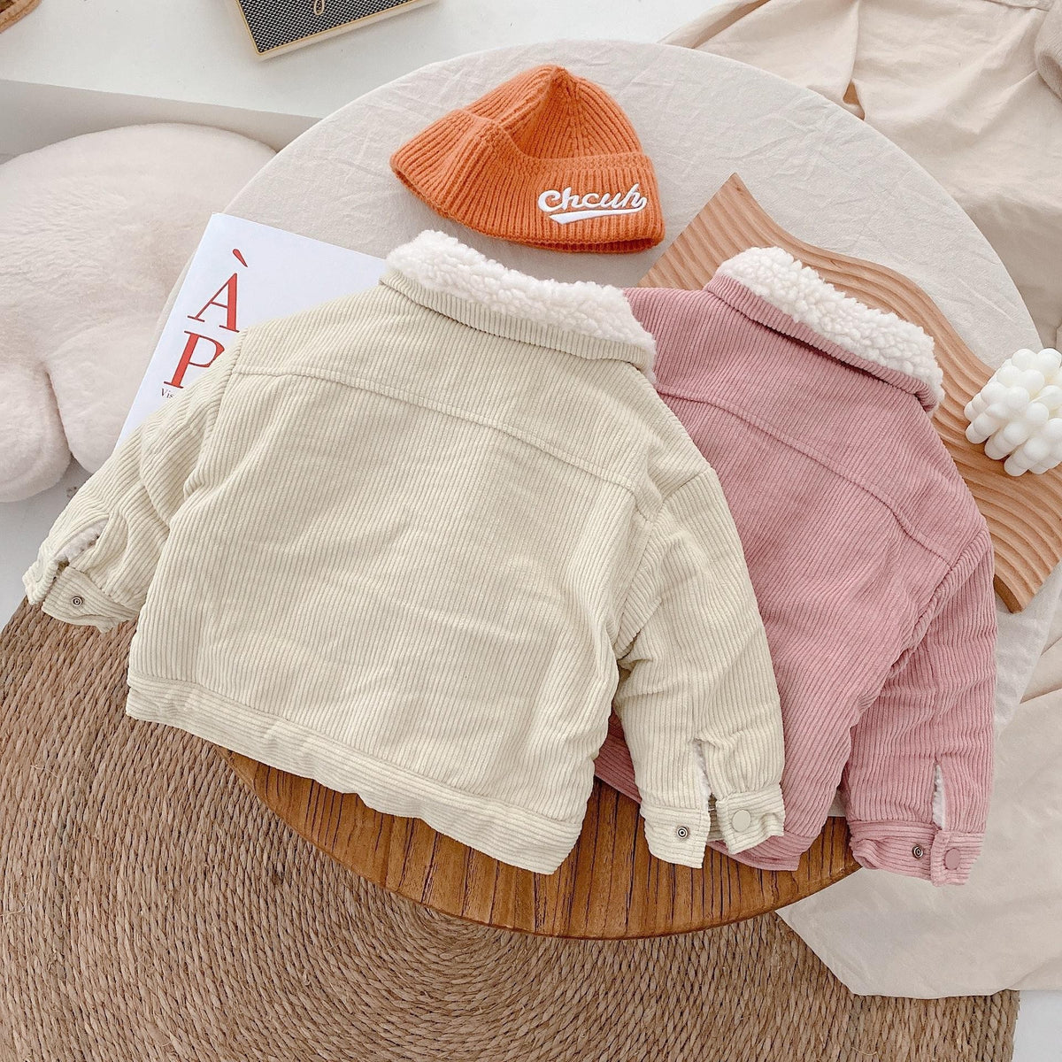 Beige and pink plush-lined corduroy coats laid flat