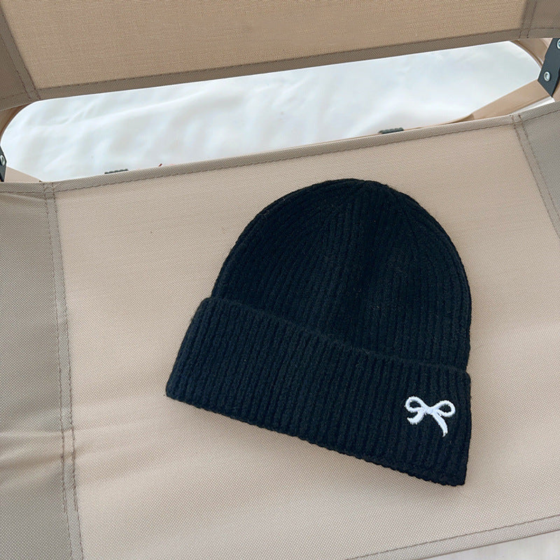 Black ribbed knit beanie with white bow