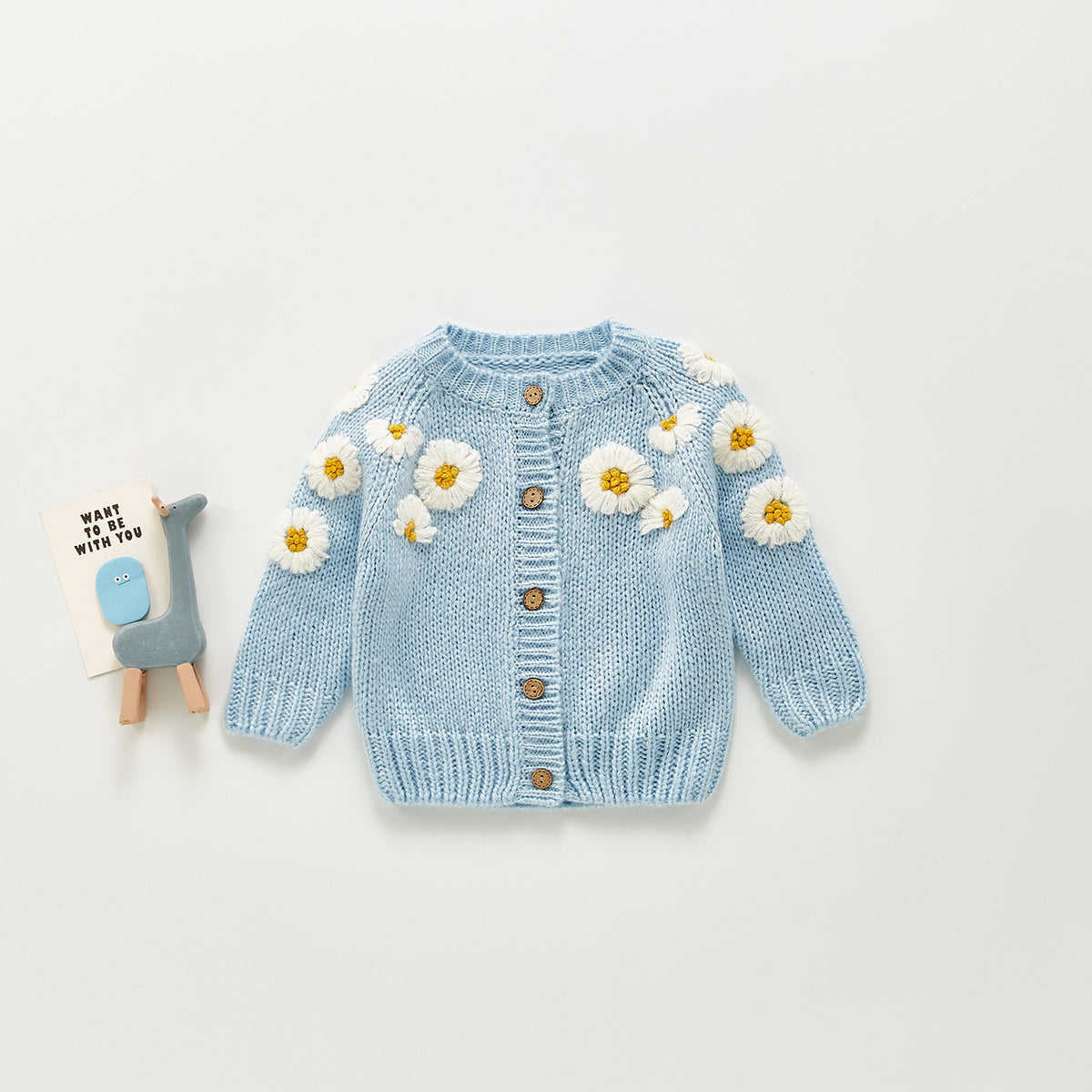 Blue knit baby cardigan with white daisy flowers