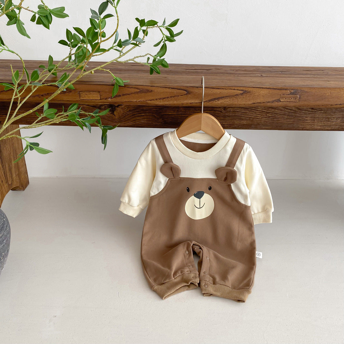 Brown bear overall jumpsuit hanging on a branch