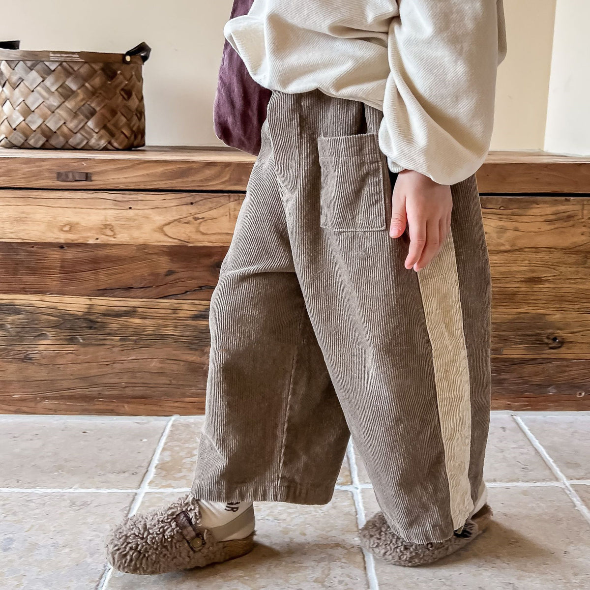 Child wearing brown corduroy wide leg pants with side stripe