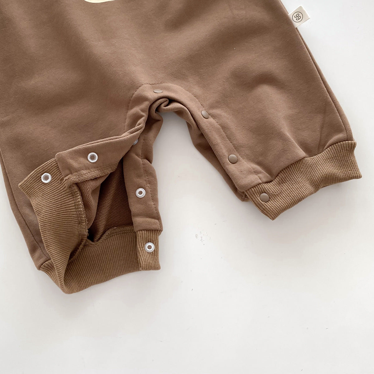 Close-up of snap crotch on brown jumpsuit