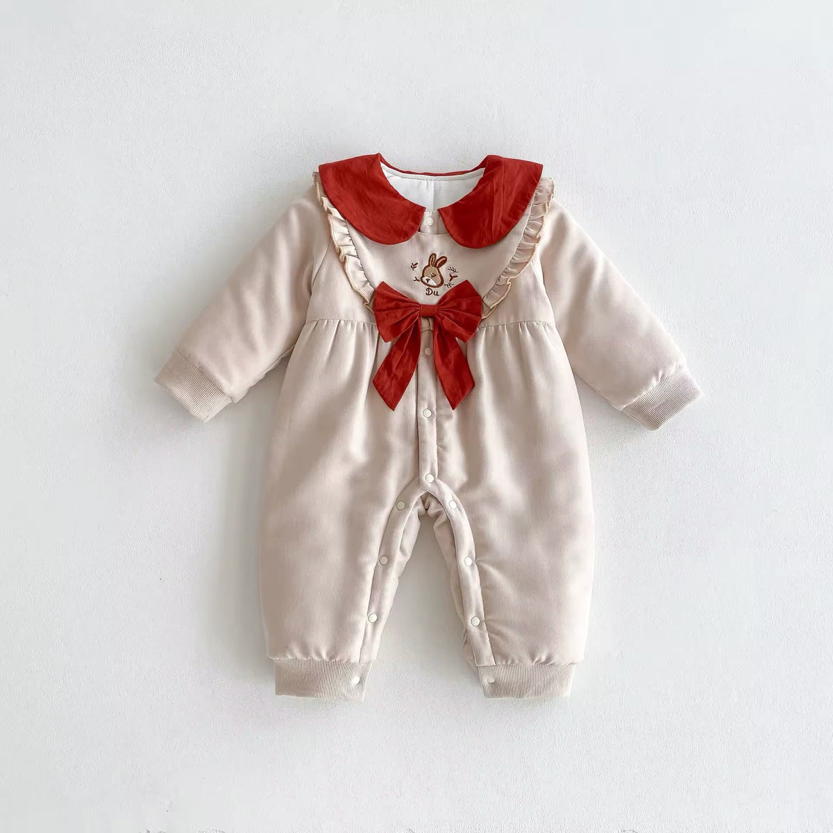 Cream fleece-lined baby romper with red collar and red bow bib