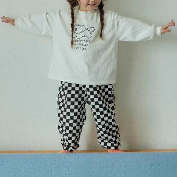 Toddler standing in black checkerboard pants
