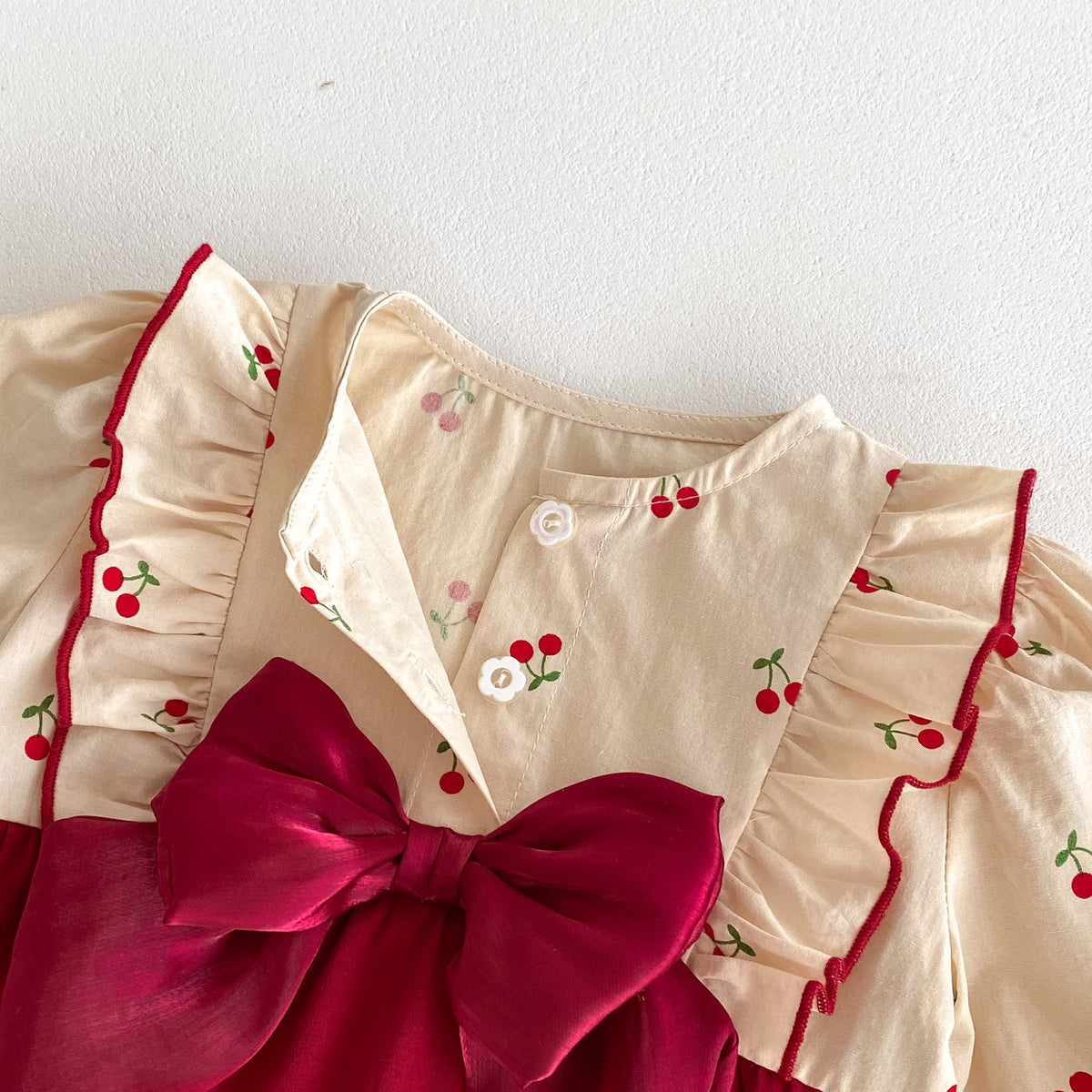 Close-up of cherry print fabric and red ruffle trim