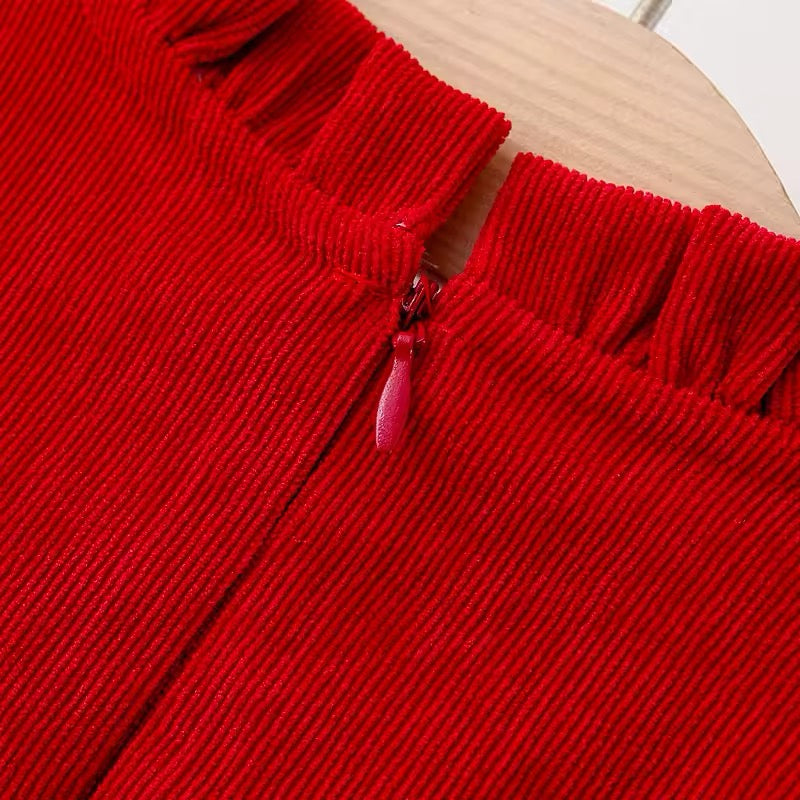Close-up of back zip and frilled neckline on red corduroy dress