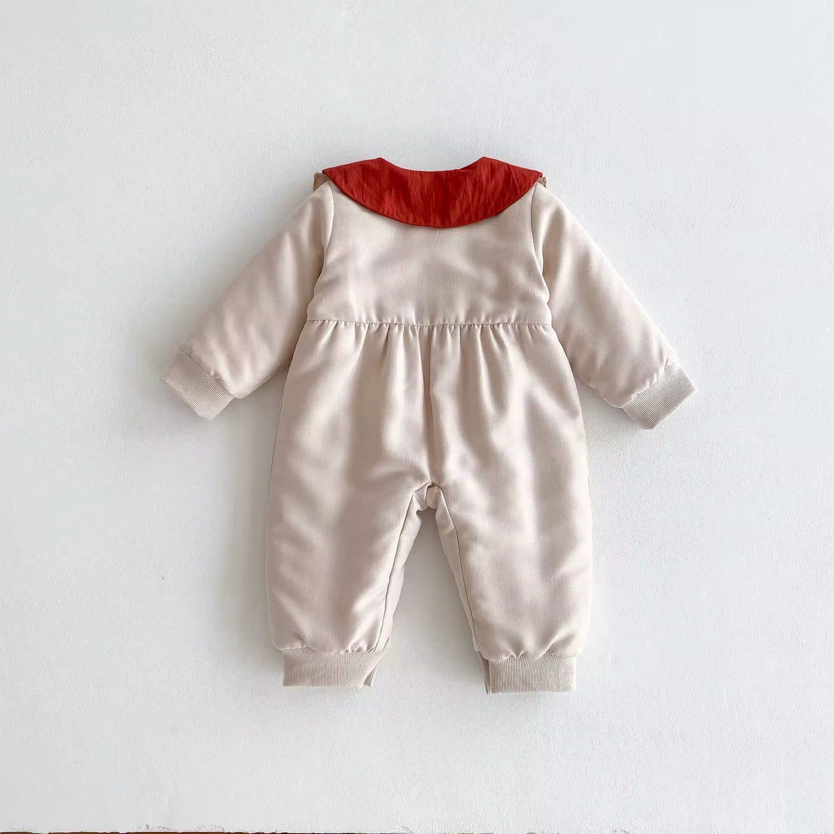Cream padded baby romper with red Peter Pan collar