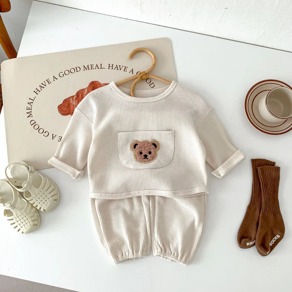 Cream waffle bear pocket set on a hanger with shoes and socks