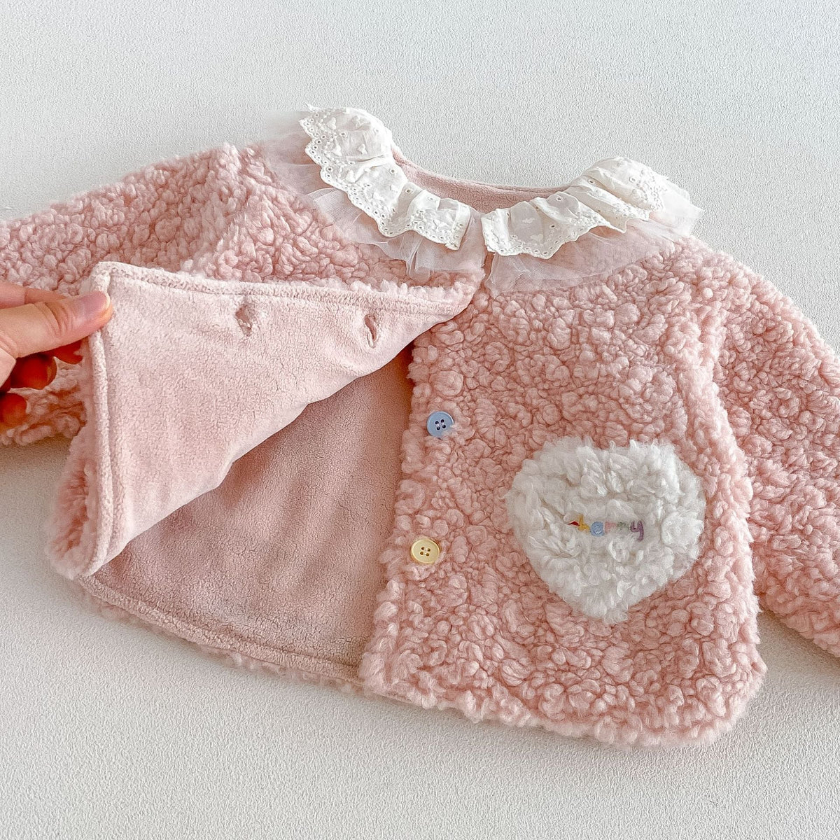 Inside of the pink sherpa jacket showing the soft plush lining