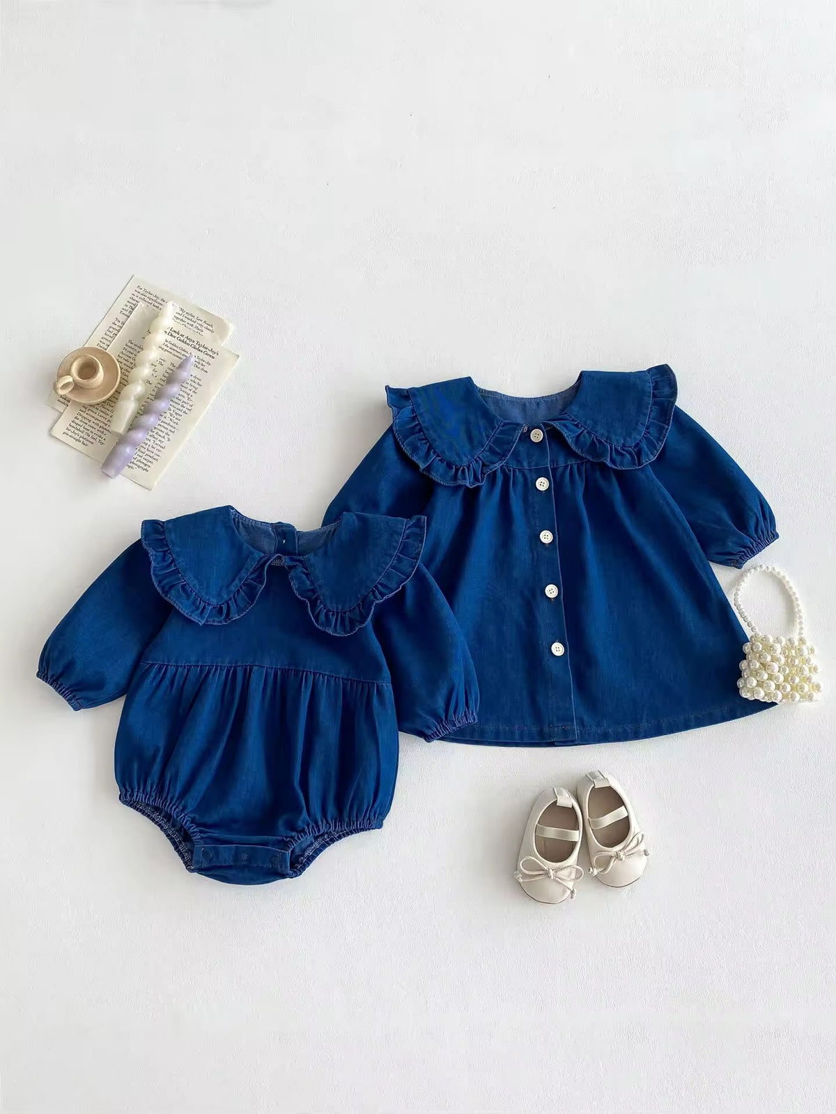 Denim baby romper and matching dress laid flat with shoes